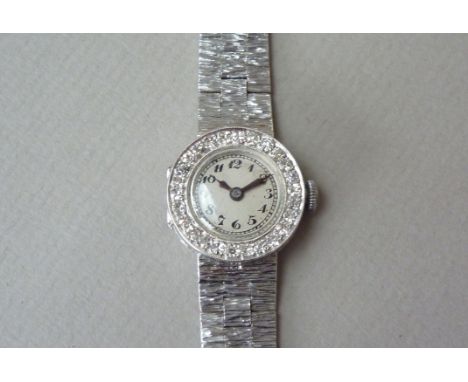 A 1960s lady's diamond-set platinum and 9 ct white gold wristlet watch, having a manual wind movement with circular silvered 