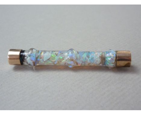 A late 19th / early 20th Century bar brooch, comprising a knopped stem of opal fragments within a glass matrix, with yellow m