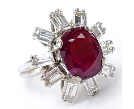 Vintage Oval Cut Ruby, Approx. 2.0 Carat Emerald Cut Diamond and Platinum Ring. Ruby measures 11mm x 9mm. Diamonds E-F color,