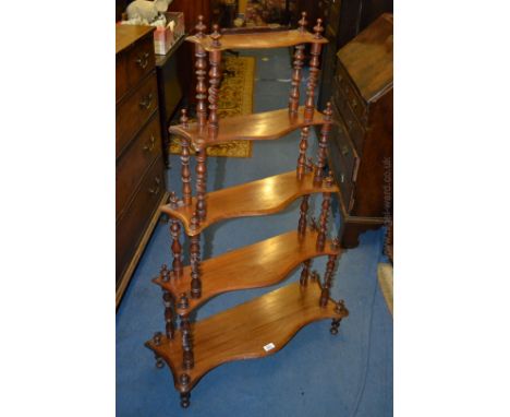 An elegant Victorian Walnut five tier serpentine Wotnot, the top tier having upstand back, the five graduated tiers separated