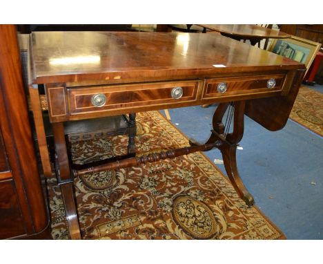 A Regency style reproduction lyre end Sofa Table having cross banded top, end drop leaves, having two frieze drawers to one s