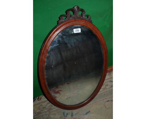 An oval mahogany framed wall hanging Mirror