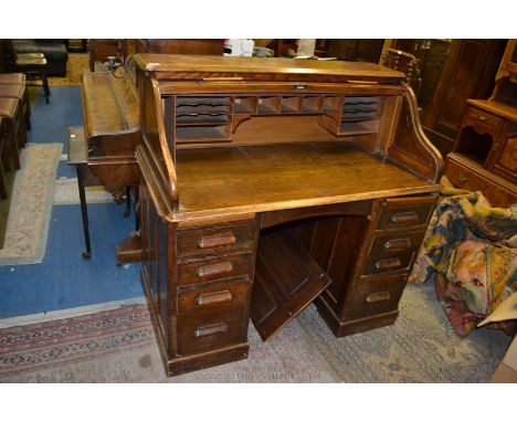 A good Ministry roll top Desk having plain top, the tambour roller opening to reveal fifteen pigeon holes and two secrete dra