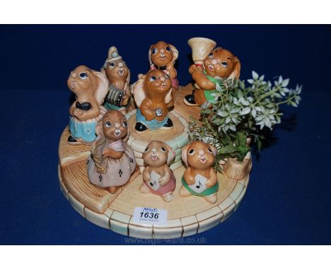 A Pendelfin circular stand with eight musical rabbit figures - Megan the harp, Bongo, Maud, Clanger, Ingle, two Rollys and Sq