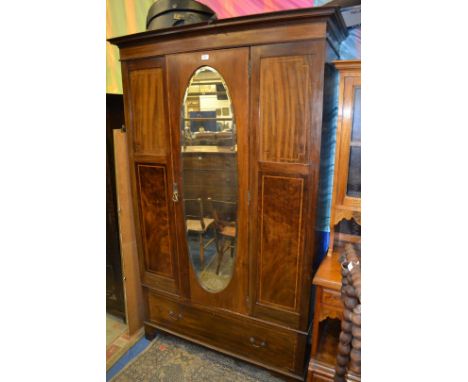 An Edwardian Mahogany single door Wardrobe with moulded cornice over the central single door featuring oval bevel plate mirro