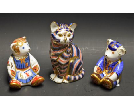 A Royal Crown Derby paperweight, Schoolgirl Teddy, gold stopper; another, Schoolboy Teddy, gold stopper; another, Seated Cat,