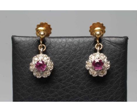 A PAIR OF EDWARDIAN RUBY AND DIAMOND CLUSTER EARRINGS on screw back fittings stamped 9ct (Est. plus 24% premium inc. VAT)  Co