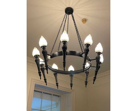AN EBONISED METAL TEN LIGHT CHANDELIER, 20th century, the circlet suspended from chains and issuing torches with glass faux f
