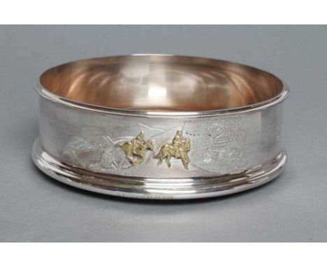 A SILVER BOTTLE COASTER, maker Hancocks, London 1991, of plain cylindrical form, engraved with hunting, shooting and fishing 