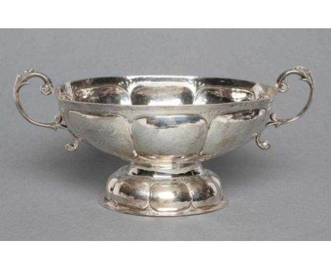 AN EDWARDIAN SILVER TWO HANDLED BOWL, maker Bertholdt Muller, Chester import mark, 1903, of oval form chased with lobes, on a