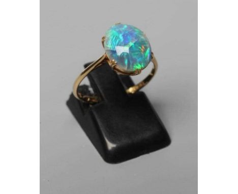 T. GAUNT - a black opal ring, the oval cabochon polished stone claw set to a plain shank, stamped 15ct, T. Gaunt, size M 1/2,