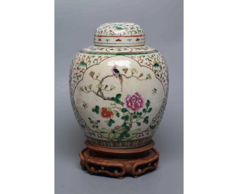 A CHINESE JAR AND COVER of ovoid form, painted in colours with two quatrefoil panels enclosing exotic birds and moths amidst 