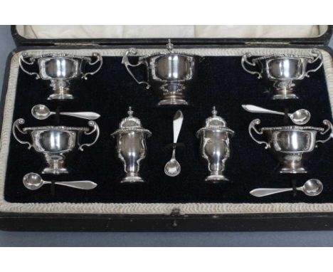 A SEVEN PIECE SILVER CRUET, maker Manoah Rhodes, London 1918, of campana form with everted gadrooned rims, comprising four sa