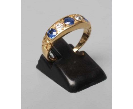 A LATE VICTORIAN SAPPHIRE AND DIAMOND HALF HOOP RING, the three sapphires and two diamonds gypsy set to reeded shoulders and 