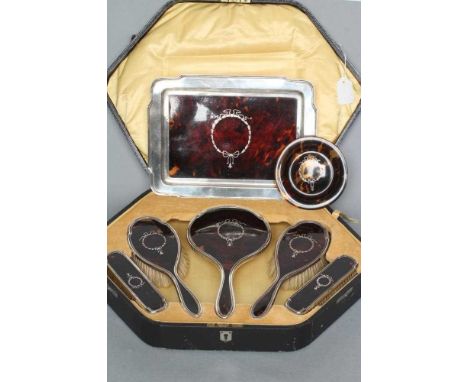 A SILVER AND TORTOISESHELL PIQUE WORK DRESSING TABLE SET, maker's mark WGC &amp; Co., Birmingham 1919, comprising circular be