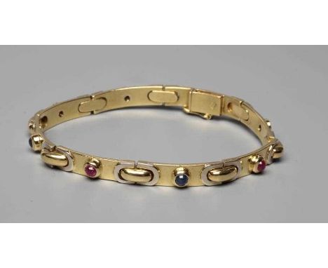 A BRACELET stamped 750, the seven slightly convex oblong panels alternately set with a cabochon polished ruby or sapphire (Es