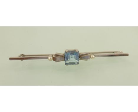 A RHODIUM FINISHED WHITE GOLD COLOURED METAL ART DECO STYLE BAR BROOCH set with central aquamarine 