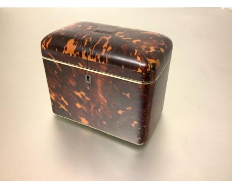 An early 19th century tortoiseshell veneered tea caddy, of plain rectangular form, with domed cover, centred by a rectangular