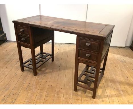 An early 20th century Chinese Export padouk wood desk, the rectangular detachable top raised on a pair of pedestals each fitt