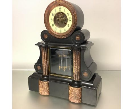 A 19th century black slate and red marble drumhead mantel clock, of architectural form, the two train movement striking on a 