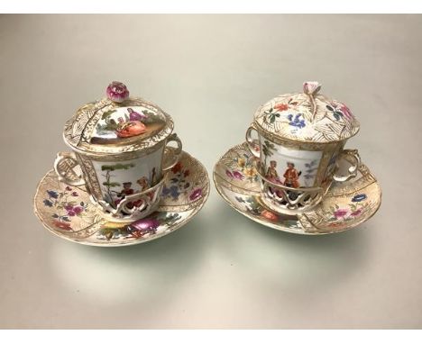 A pair of Berlin porcelain chocolate cups and covers on trembleuse saucers (one a/f), 19th century, each domed cover with flo