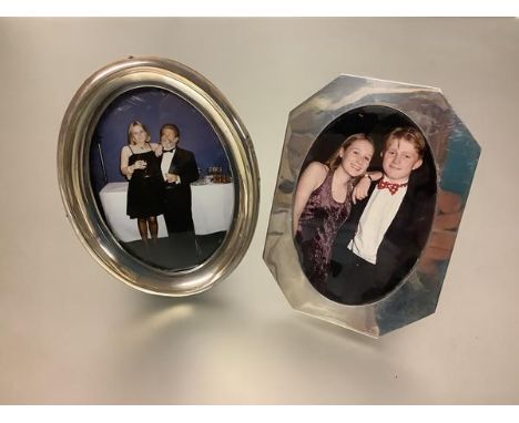 Two silver photograph frames: the first with frame of shaped ocatagonal form enclosing an oval aperture, leather easel back, 