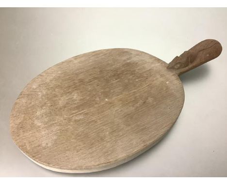 Workshop of Robert (Mouseman) Thompson, an oval oak cheese or bread board, with carved mouse signature to the handle. 39cm by