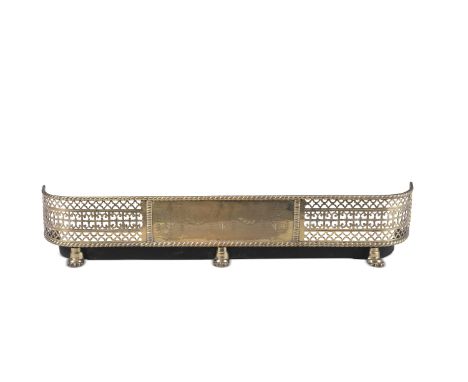 A 19TH CENTURY PIERCED BRASS CURB FENDER, with engraved central plate between pierced tracery friezes with rounded corners, a