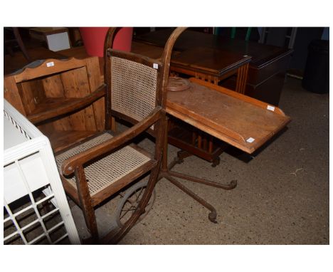 VINTAGE CANE BACKED AND SEATED INVALID CHAIR AND FURTHER ADJUSTABLE OAK AND CAST METAL FRAMED BED TABLE 