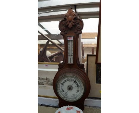 A late Victorian carved oak aneroid wheel barometer. 