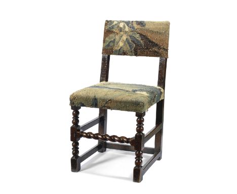 A 17th century oak chairUpholstered in a Verdure tapestry fragment on bobbin turned front legs joined by a spiral twist front