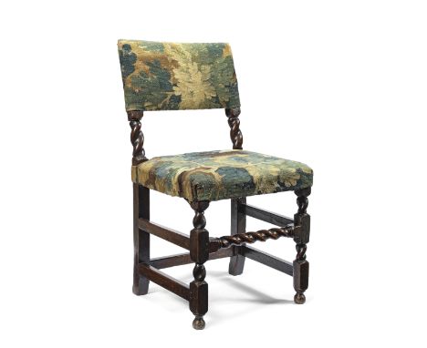 A 17th century oak chairUpholstered in a Verdure tapestry fragment with barley spiral twist uprights and a conforming front s