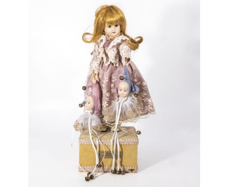 Automated musical box clock-work doll on a wooden base, the doll has a porcelain head and hands, dressed in refined clothes h