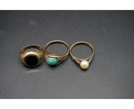 A 9ct gold and black onyx signet ring, size G 1/2; together with a yellow metal ring, set rotating jade ball, size J and anot