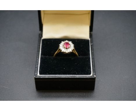 An 18ct gold ruby and diamond cluster ring, set central oval ruby surrounded by ten brilliant cut diamonds, size 0, gross wei