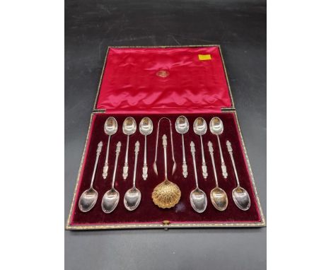 A cased set of twelve EPNS apostle teaspoons, matching tongs and sugar sifter spoon, the case inscribed The Goldsmiths &amp; 