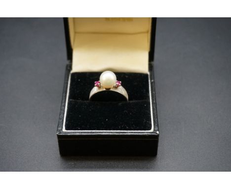 A pearl and ruby three stone ring, stamped 14k, size M1/2. 