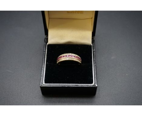 A yellow metal ruby and diamond half eternity ring, size O. 