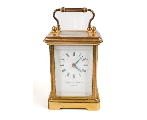 A 20th century Swiss brass carriage clock by Matthew Norman, white enamel dial with Roman numerals, inscribed Matthew Norman 