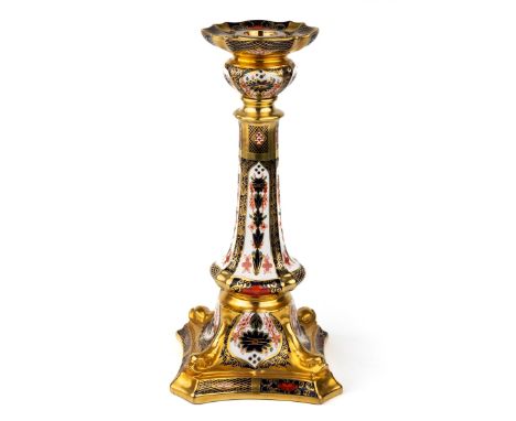 A Royal Crown Derby Old Imari 1128 solid gold band candlestick, heavily gilded with dolphin detail to square base, red printe