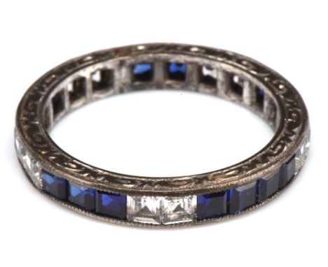 1920's sapphire eternity ring,  set with table cut blue and white sapphires, in an engraved mount testing as platinum, ring s