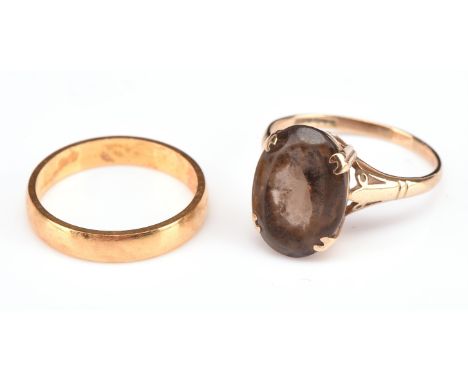 Two rings, including a wedding band, hallmarked 22 ct 1972, ring size K and an oval cut smokey quartz ring, in a cathedral se