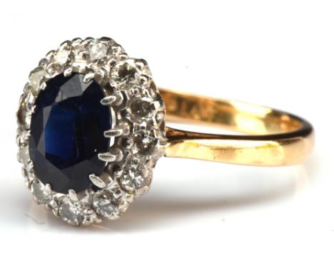 Sapphire and diamond cluster ring, set with a central oval sapphire estimate as 1.76 carats, surrounded by 12 round cut diamo