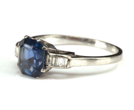 Art deco sapphire and diamond ring, set with an emerald cut blue sapphire estimated weight 2.79 carats, with three baguette c