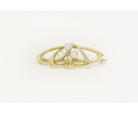 An Art Nouveau gold brooch, set with a demantoid garnet and opal trifoil shamrock, marked 15ct, in a Frederick Dixon box,3.54