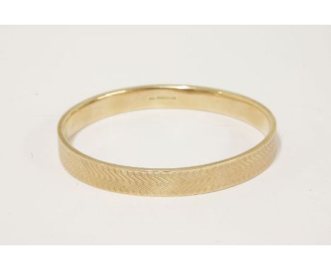 A 9ct gold slave bangle, with engine turned decoration, dated 1921,16.10g