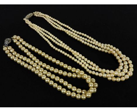 A three row cultured pearl necklace, with paste stone clasp, and a two row simulated pearl necklace with paste stone clasp