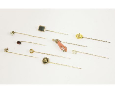 A gold single stone diamond stick pin, claw set to a scalloped collet, in box, a collection of stick pins to include a gold p