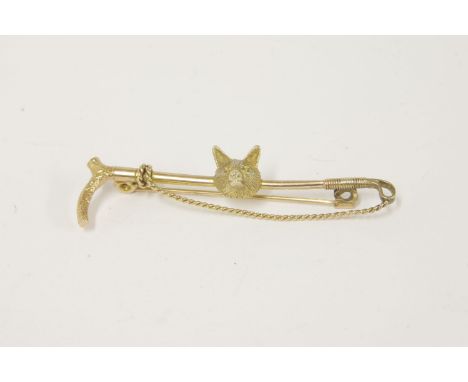 A gold riding crop stick pin, mounted with a fox head, marked 9ct6.24g