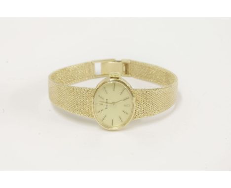 A ladies 9ct gold Tissot mechanical bracelet watch, with baton numerals and integral textured Milanese strap, London dated 19